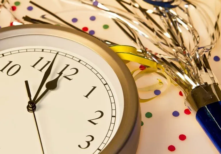 Clock and champagne bottle with sparklers coming out representing new years